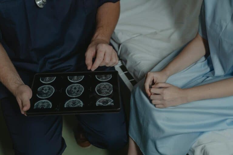 A doctor shows and explains brain scan images to a patient in a medical setting.